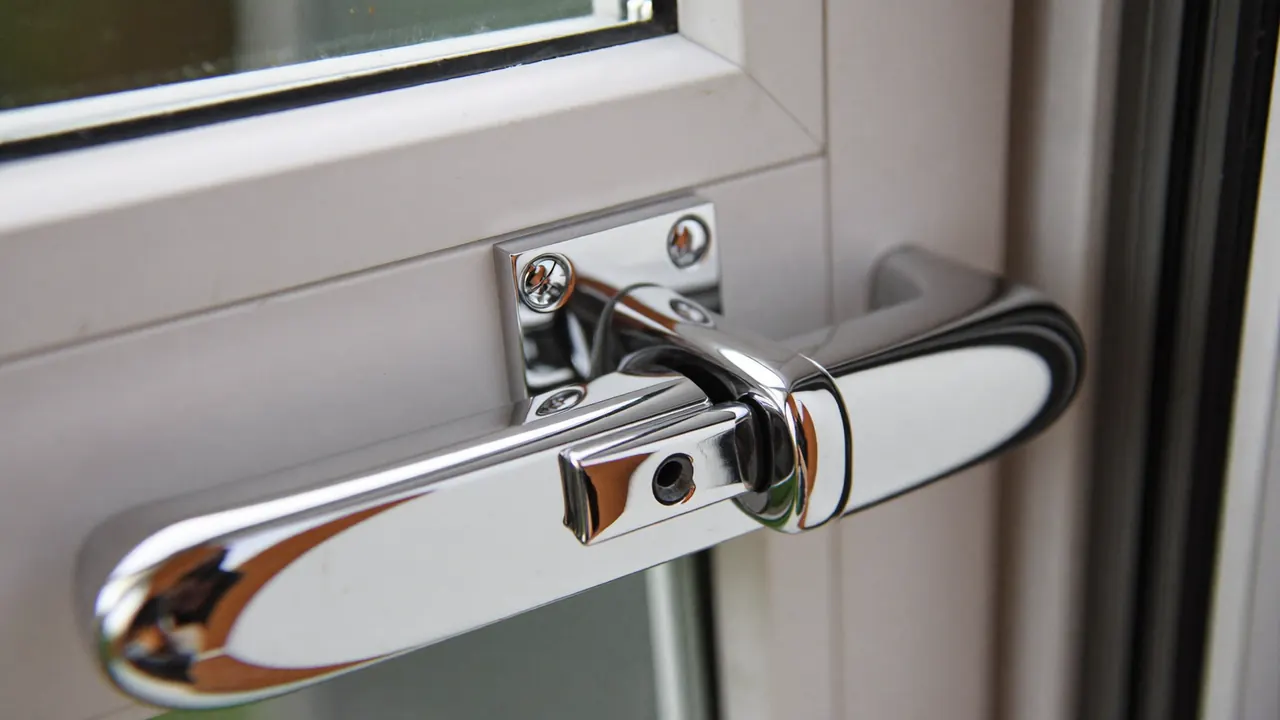 Close-up of a chrome casement window handle and multi-point locking mechanism
